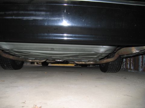 1991 Ford LTD Crown Victoria - The underside of a black car is visible, showing the exhaust pipes and tires.
