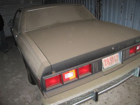 1991 Ford LTD Crown Victoria - A dusty sedan is parked indoors, showing its rear end and license plate.