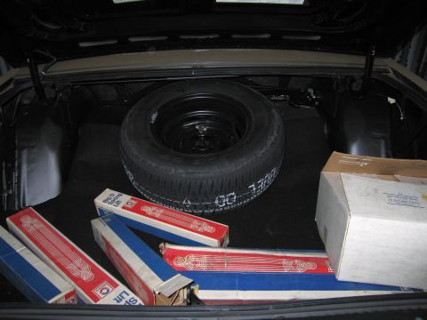 1991 Ford LTD Crown Victoria - Car trunk interior showing a spare tire and boxes of car parts.