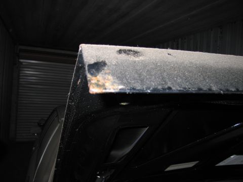 1991 Ford LTD Crown Victoria - The corner of a car's hood shows signs of rust and wear, with another vehicle in the background.
