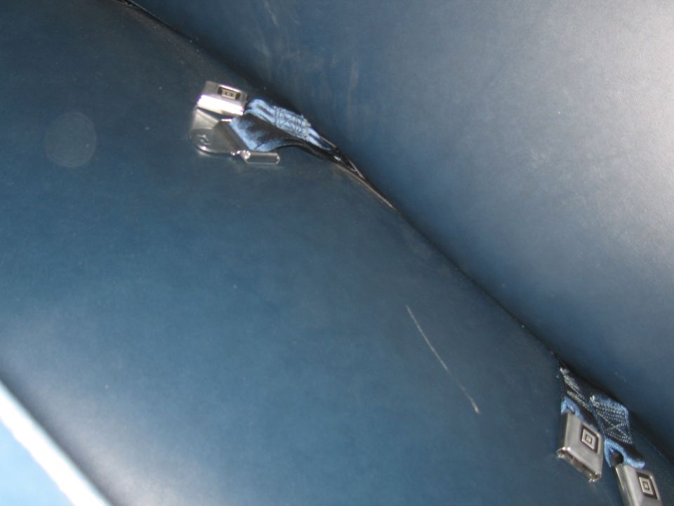 Blue interior ceiling with two chrome seatbelt buckles and straps