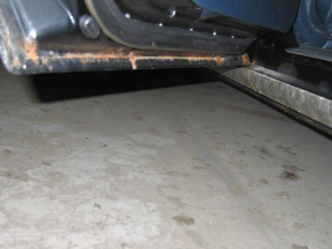 1991 Ford LTD Crown Victoria - The lower edge of a car door shows significant rust and wear.