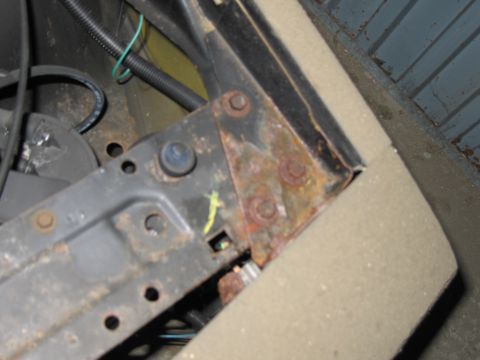 1991 Ford LTD Crown Victoria - Detail of a corroded metal bracket and electrical wiring, likely from a vehicle's engine bay.