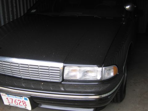 1991 Ford LTD Crown Victoria - This black sedan is parked indoors, showing its front grille and headlights.