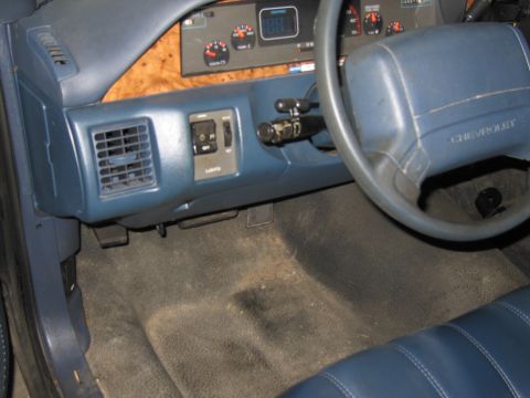 1991 Ford LTD Crown Victoria - Interior view of a Chevrolet, showing the dashboard, steering wheel, and floor mats.