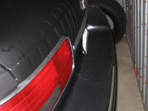 1991 Ford LTD Crown Victoria - A close-up view of the rear of a black car, showing the taillight and a license plate.