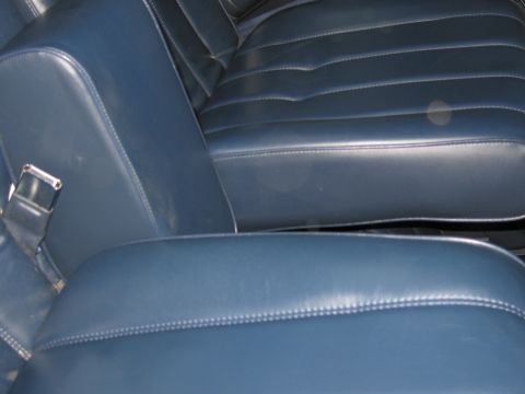 1991 Ford LTD Crown Victoria - Close-up of the blue vinyl interior of a vehicle, showing the seats and armrest.