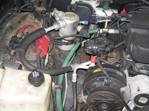 1991 Ford LTD Crown Victoria - Close-up view of the engine bay, highlighting the air conditioning system and coolant reservoir.
