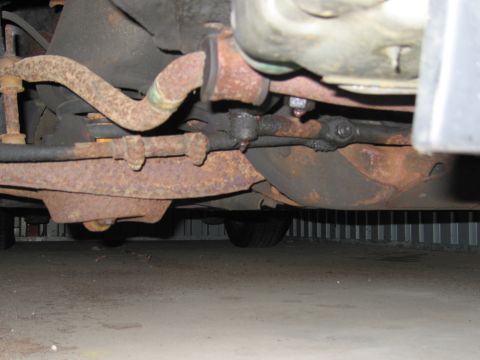 1991 Ford LTD Crown Victoria - The undercarriage of a vehicle displays significant rust on its suspension and steering parts.