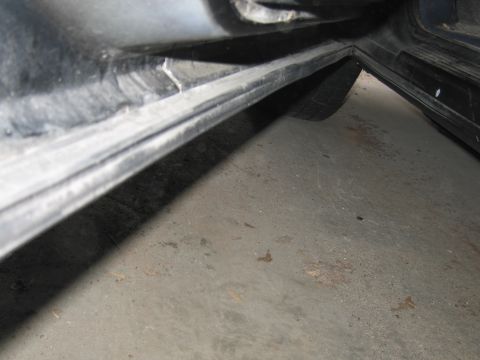 1991 Ford LTD Crown Victoria - Close-up of a car's door sill and the surrounding concrete floor.