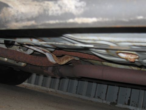 1991 Ford LTD Crown Victoria - Photograph of a vehicle's rusted exhaust and underbody seen from below.