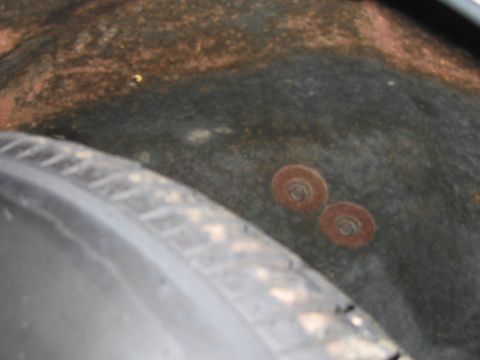 1991 Ford LTD Crown Victoria - Photograph of a rusty trunk spare-tire area beside a tire.