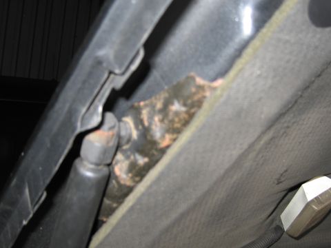 1991 Ford LTD Crown Victoria - Photograph of rust and corrosion at a body seam near a hinge inside a vehicle.