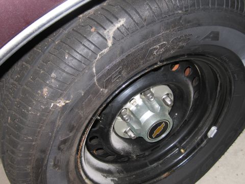 1991 Ford LTD Crown Victoria - Photograph of a Chevrolet steel wheel and tire with bowtie center cap.