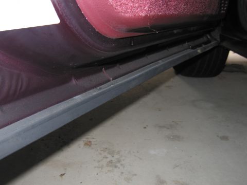 1991 Ford LTD Crown Victoria - Photograph of a door sill and rocker panel, not a technical document.