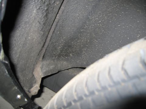 1991 Ford LTD Crown Victoria - Photograph of a vehicle wheel well and undercarriage, not a technical document.