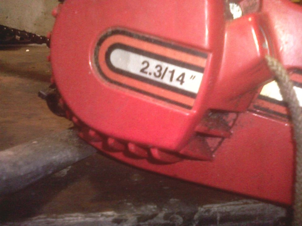 Red chainsaw housing with "2.3/14" text