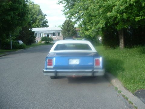 1987 Ford Crown Victoria LTD - Rear view of a blue sedan with a white roof parked on a residential street. The vehicle's design suggests it is from the late 1970s or earl…