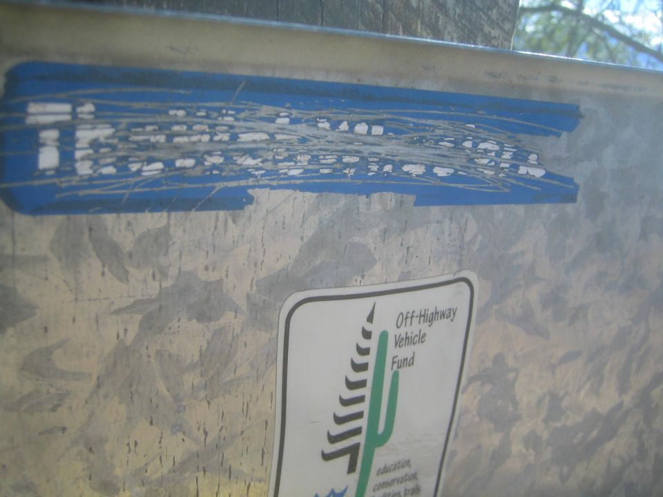 Close-up of a metal surface with a blue sticker and an 'Off-Highway Vehicle Fund' sticker