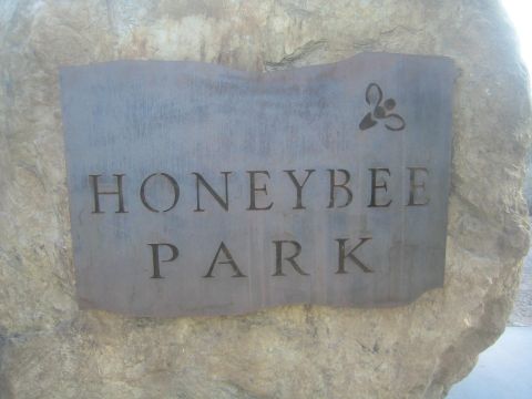 1968 Ford Mustang - A metal sign with the words 'HONEYBEE PARK' is mounted on a large rock, a stylized bee logo.