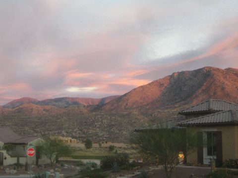 1968 Ford Mustang - Sunset over a desert landscape with mountains, houses, and a stop sign visible.