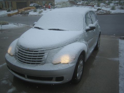 1968 Ford Mustang - A silver Chrysler PT Cruiser is covered in snow on a driveway.