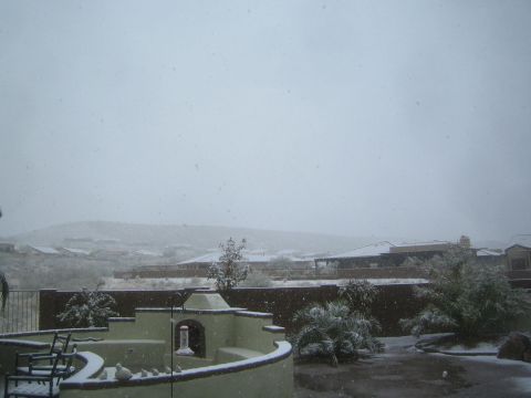 1968 Ford Mustang - Snowfall covers a backyard patio and surrounding landscape with houses visible in the distance.