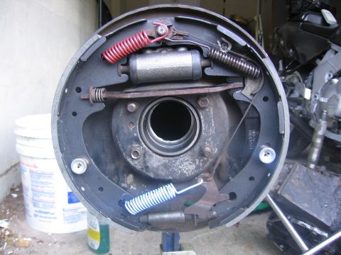 1989 Ford Bronco - Close-up view of a vehicle's brake drum assembly, showing the brake shoes, springs, and wheel cylinder.