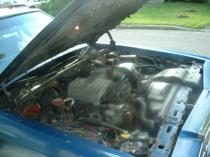 Blue car engine bay with hood open