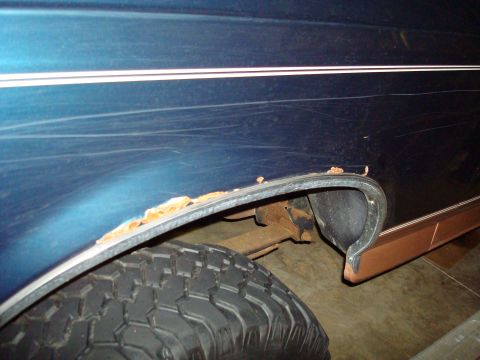 1995 Ford Bronco - The wheel well of this vehicle shows significant rust damage along the fender edge.