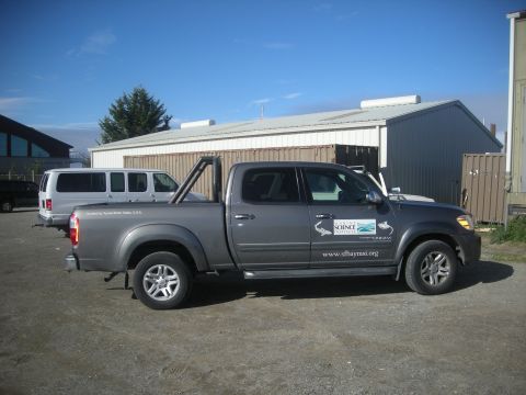 1991 Ford Bronco - A gray pickup truck with scientific decals is parked in front of a building.