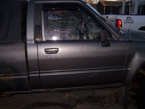 1988 Toyota Pickup/SR5 - This 1988 Toyota Pickup SR5 shows rust on its lower body panels and a bed cap.