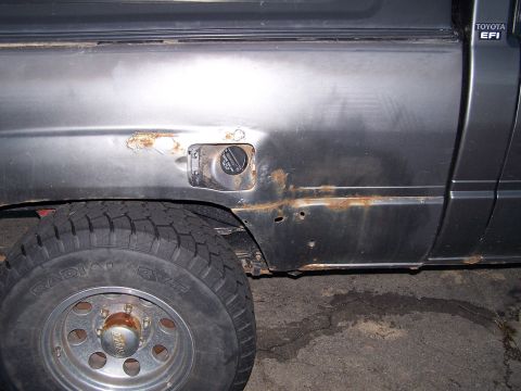 1988 Toyota Pickup/SR5 - This 1988 Toyota Pickup/SR5 shows significant rust on its rear quarter panel near the fuel door.