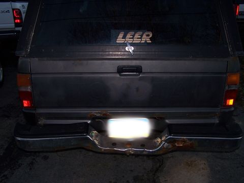 1988 Toyota Pickup/SR5 - The rear bumper of the truck shows significant rust damage.