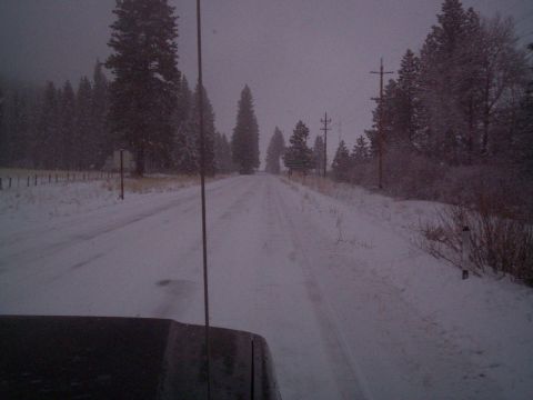 1986 Ford Bronco - Driving on a snow-covered road through a wooded area with power lines visible.