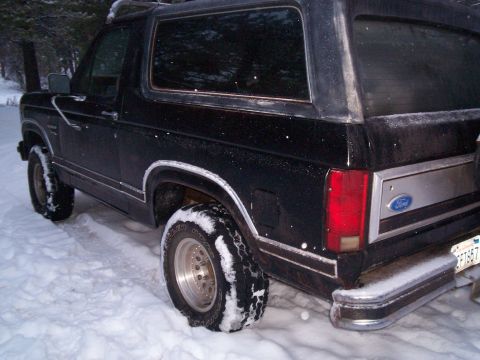 1986 Ford Bronco - This 1986 Ford Bronco is seen from the rear, parked in a snowy outdoor setting.