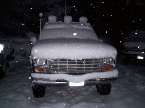 1986 Ford Bronco - Front view of a 1986 Ford Bronco buried in snow during a winter storm.