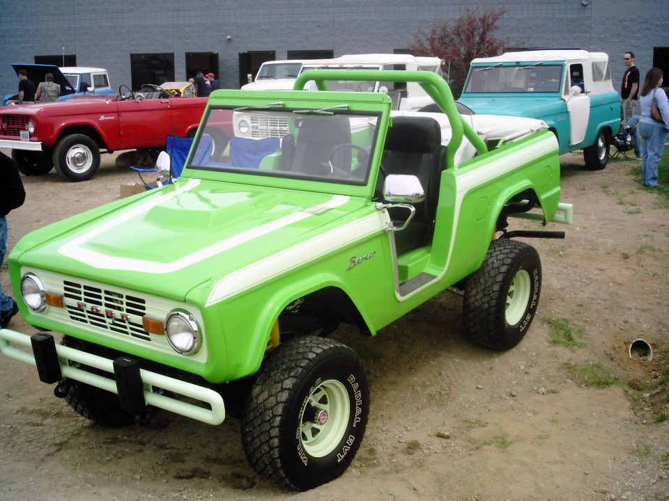 Lime green doorless early Ford Bronco with roll bar at an outdoor show
