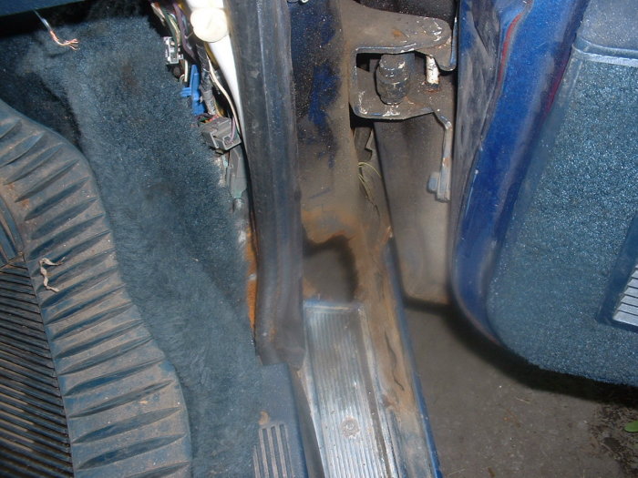 Interior driver's side footwell with blue carpet and pedals