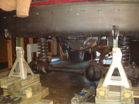 1992 Ford Bronco - Vehicle's front axle and suspension components are supported by jack stands for maintenance.