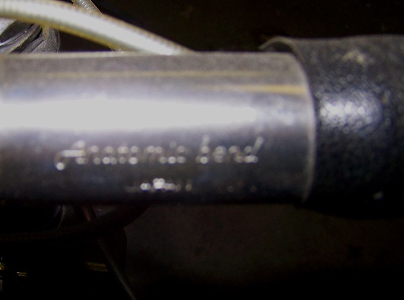 Close-up of a metal pipe with stamped text that reads 'Anatcmic bend'