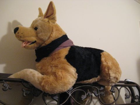 1978 Ford Bronco - A plush toy German Shepherd is positioned on a decorative metal shelf against a plain wall.
