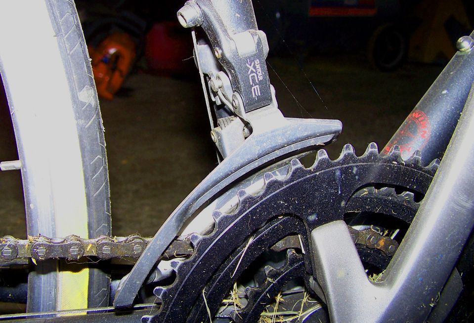Close-up of bicycle front derailleur mechanism and chainring with visible chain