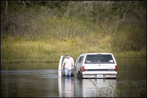 1996 Ford F-150 - A man stands in the water next to a white Ford Bronco II that appears to be stuck in a body of water.