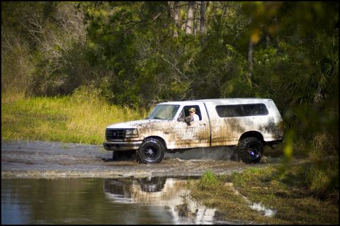 1996 Ford F-150 - Muddy 1996 Ford F-150 navigating a water crossing with a camper shell.