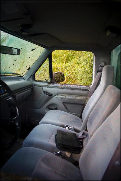 1996 Ford F-150 - The interior of a truck shows three seats and a muddy windshield, suggesting a model year around 1992.