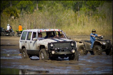 1996 Ford F-150 - Muddy Jeep Cherokee XJ navigating a rough terrain with an ATV in the background.