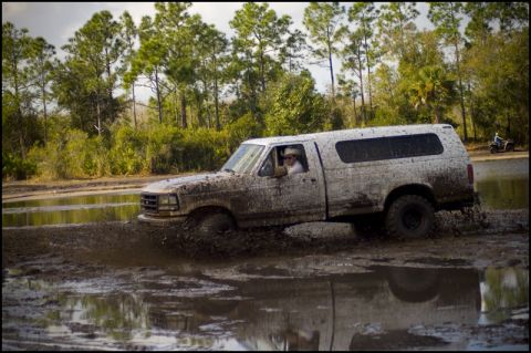 1996 Ford F-150 - Muddy 1996 Ford F-150 navigating a water-filled off-road course.