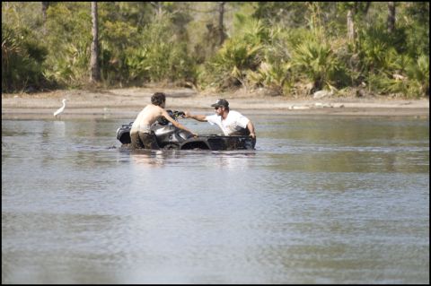 1996 Ford F-150 - ATV stuck in water with two people trying to push it out.