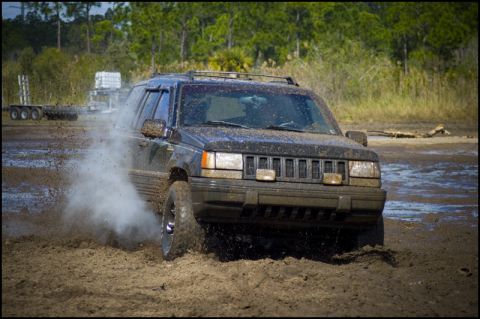 1996 Ford F-150 - A 1996 Jeep Grand Cherokee navigates a muddy terrain, off-road course.